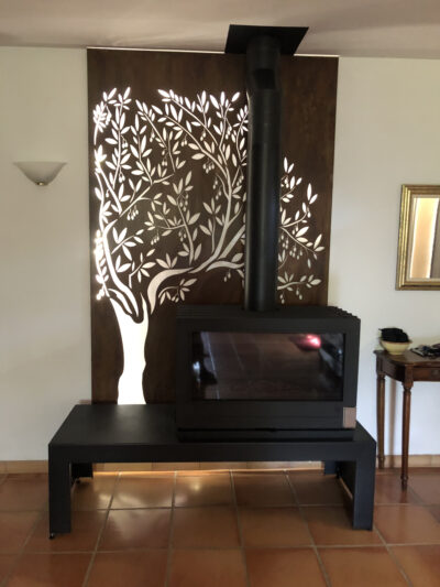Comme avec cette tôle placée derrière ce poêle, intégrez la découpe laser à votre décoration d'intérieur.